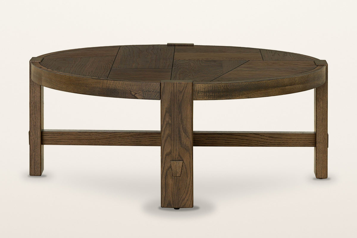 Mondavio coffee table in Smokey Chestnut from the side on a warm white studio backdrop: a leg seen edge-on in front