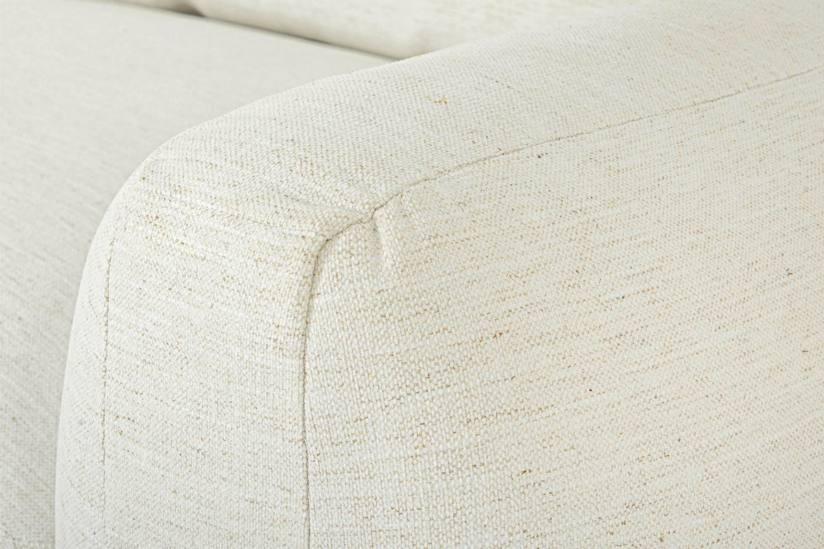 Close-up of the Montecassiano arm in Cream: a domed, rounded front in an ivory weave with fine golden flecks