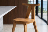 Close-up of the Montegiorgio chair: the flat teak top rail, the two posts in an inverted V and the round two-board seat