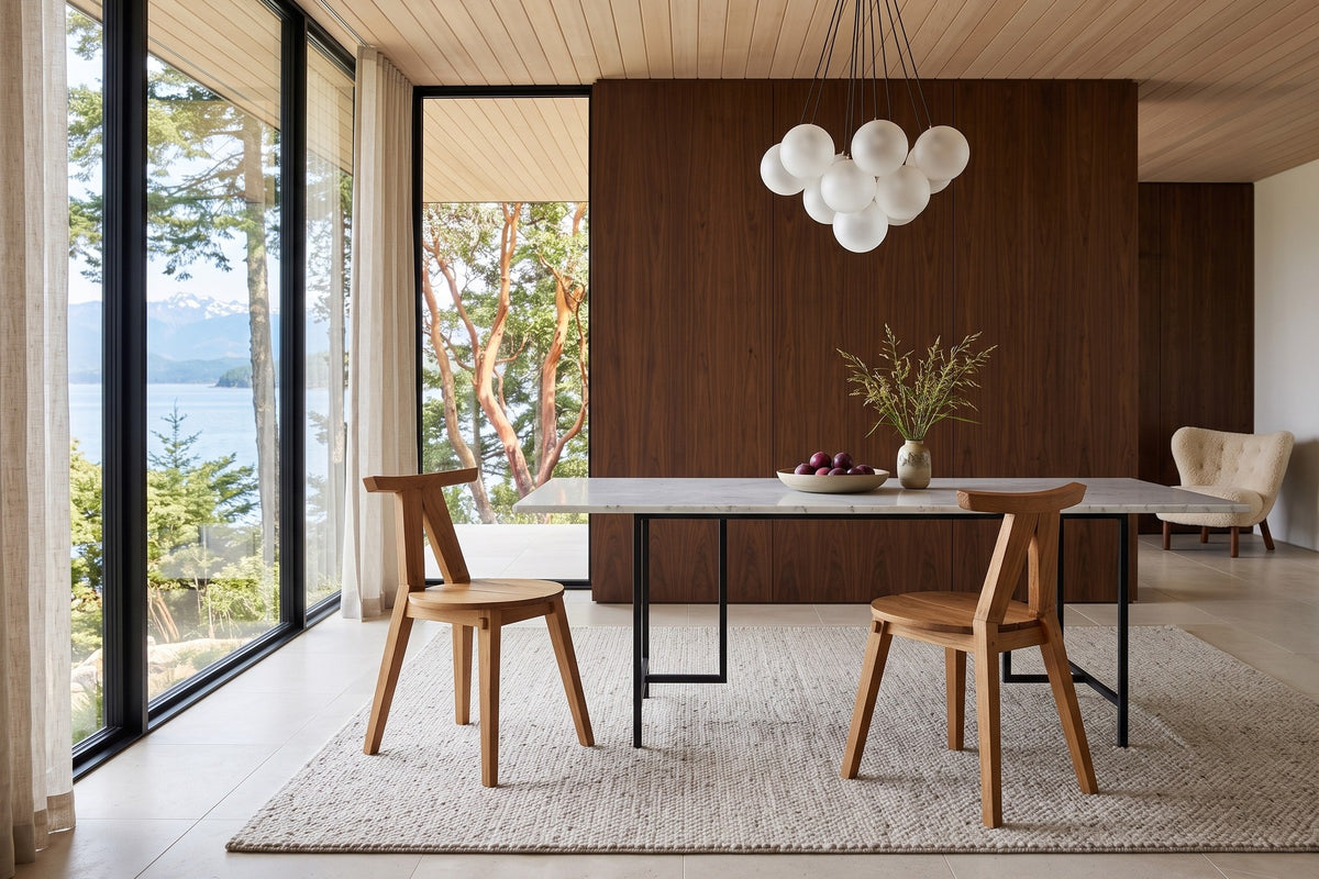Two Montegiorgio dining chairs at a white marble table in a Denman Island house, with walnut panelling