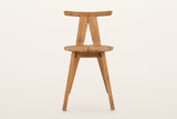Montegiorgio dining chair, straight front view on a warm white studio backdrop: the two posts meet under the top rail in an i