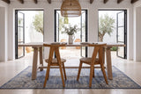 Two Montegiorgio dining chairs seen from behind at a limewashed oak trestle table in a courtyard house in Vejer de la Fronter