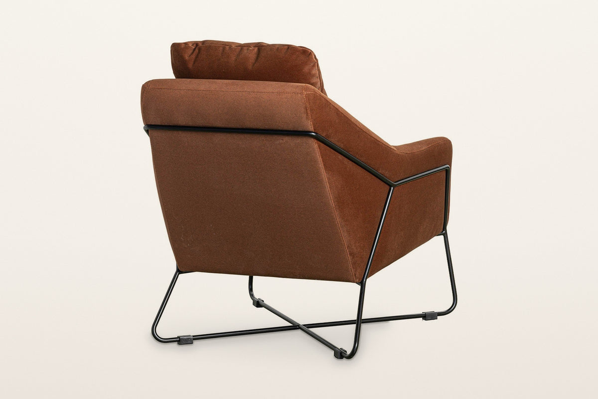 Montelupone accent chair in Rust from the back at three-quarter on a warm white studio backdrop