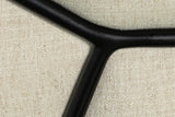Close-up of the Montelupone frame: the black iron rod meets in a Y on the Taupe linen-blend fabric