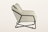 Montelupone accent chair in Taupe, side view on a warm white studio backdrop: the black rod runs along the side and up the ba