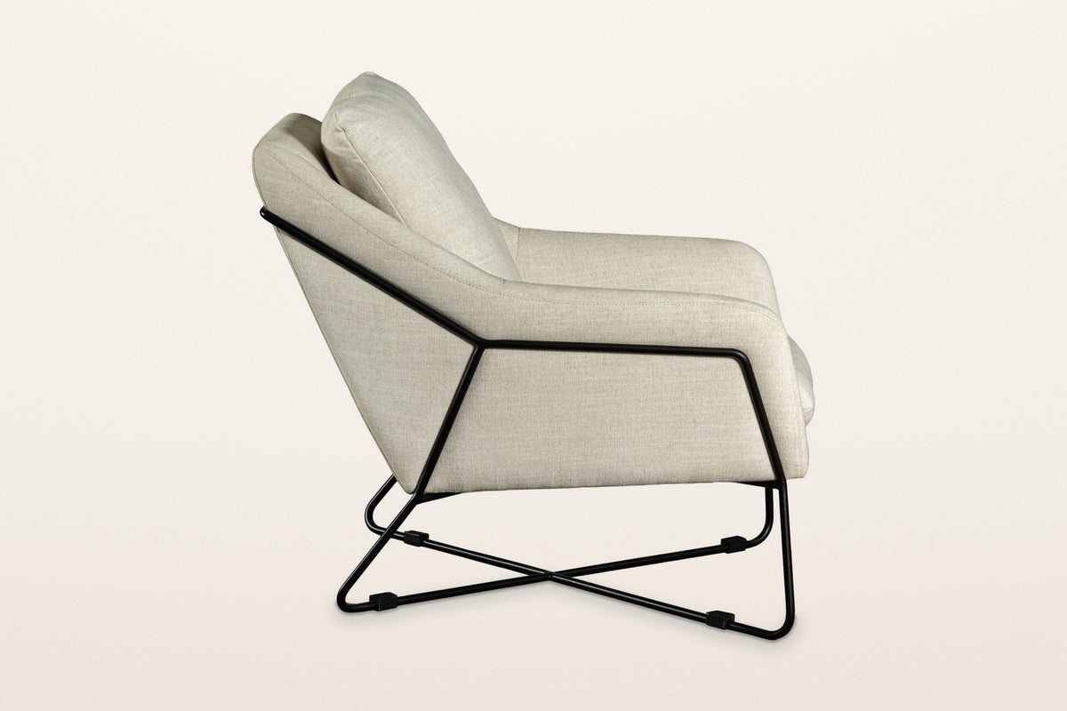 Montelupone accent chair in Taupe, side view on a warm white studio backdrop: the black rod runs along the side and up the ba