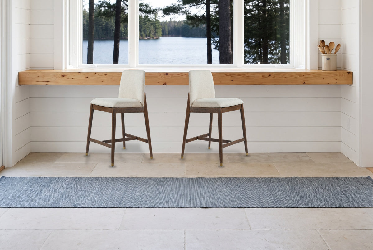 Two walnut-finish Monteriggioni counter stools in front of a pine counter and a window onto a lake in a white shiplap Muskoka