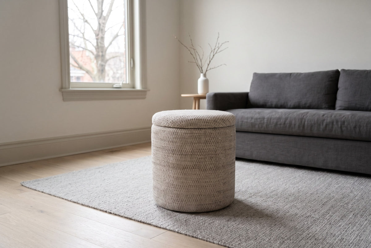 Morgex pouf in Beige on a stone-grey wool rug in a Glebe living room in Ottawa, a charcoal linen sofa behind and a bare maple through the window