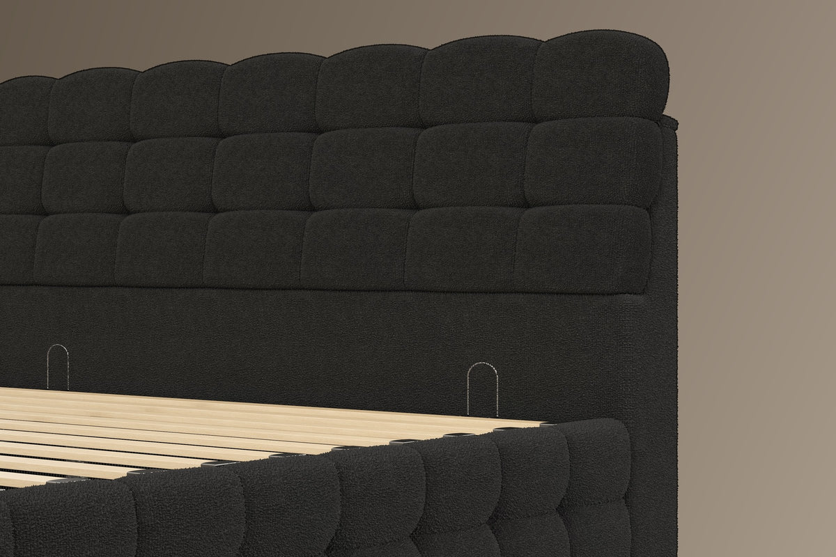 Close-up of the black bouclé headboard blocks, the plain band below and its two small metal loops