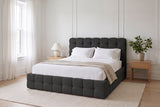 Nemi bed in black bouclé made up with white linen in a bright Montreal bedroom with wall mouldings