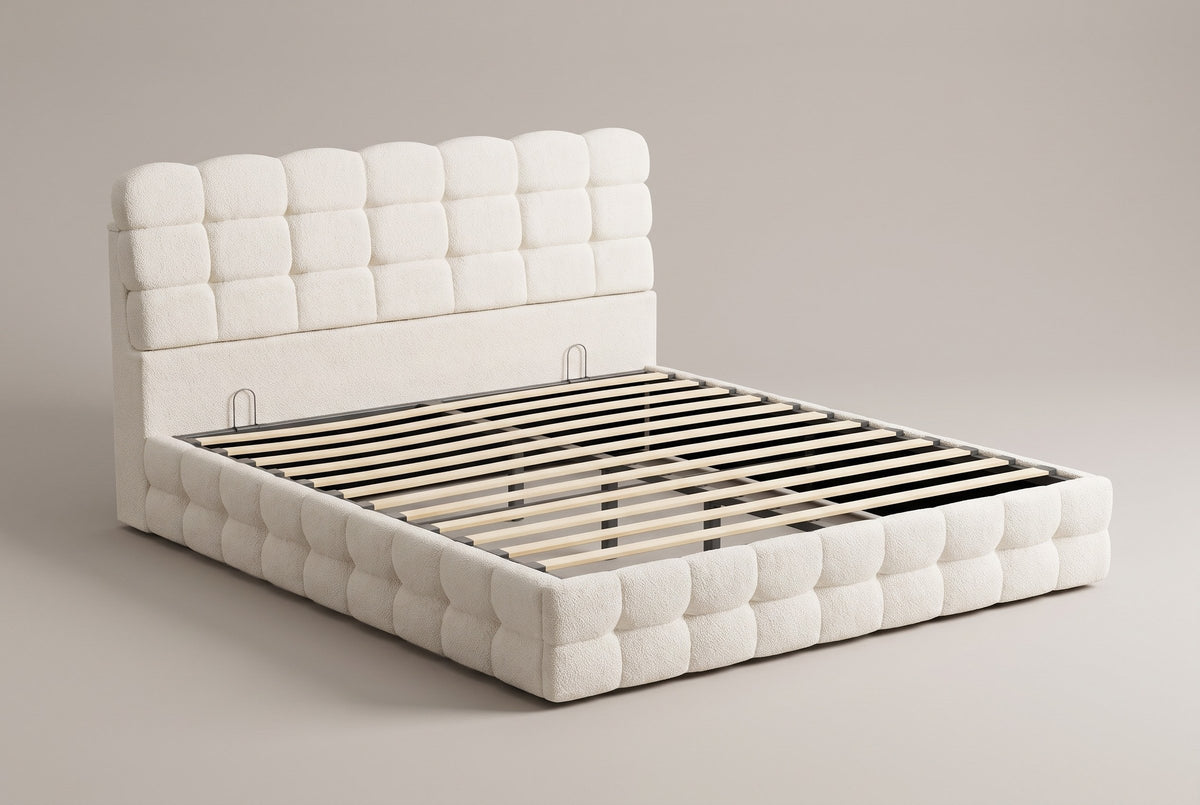 Nemi storage bed in cream white bouclé, three-quarter view of the bare frame with slats on a warm grey studio backdrop