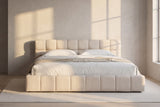 Noto bed in a plaster-walled bedroom at golden hour, window light falling across the wall