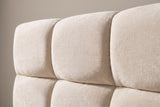 Close-up of the beige chenille headboard blocks and the deep sewn channels between them