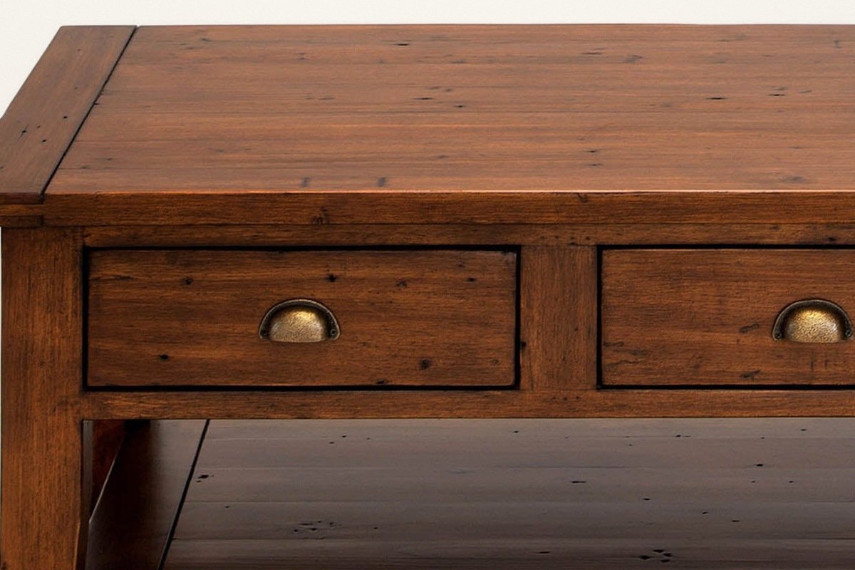 Close-up of the Novella coffee table front in African Dusk: the plank top edge, a drawer and its antique brass cup pull