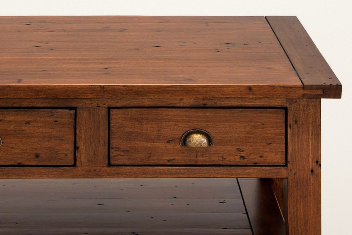 Close-up of the Novella coffee table in African Dusk: the breadboard end of the plank top over a drawer and a square leg