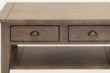 Close-up of the Novella coffee table front in Sundried: the plank top, the two drawers and their antique brass cup pulls