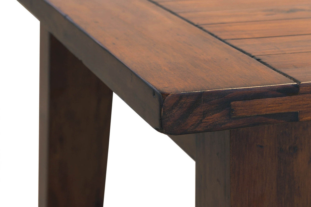 Corner of the Novella tabletop showing the breadboard-style end and distressed reclaimed pine