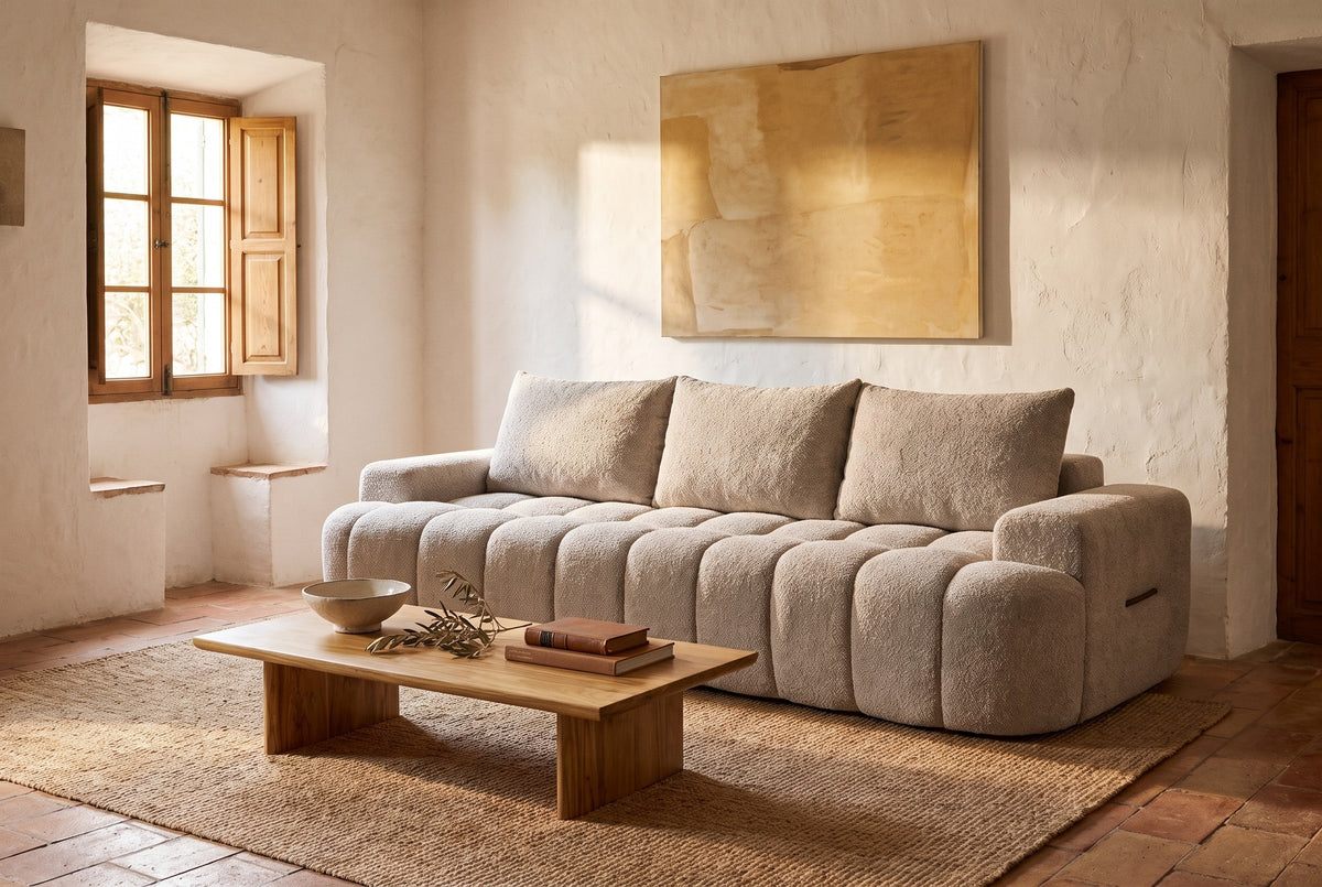The Nuvola sofa in Camel in a stone house in Deia, Mallorca, with lime-washed walls, terracotta floor, a jute rug and an olive-wood coffee table