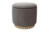 Nyla round storage ottoman in warm charcoal fabric on a reeded wood base, front view