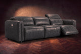 The Octavia 3 seat in Aged Slate distressed full leather on a dark herringbone floor, the right recliner open and its headrest raised. Shown in Aged Slate, 3 seat.
