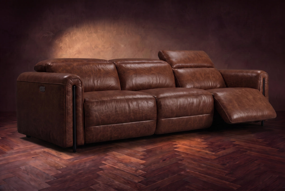 The Octavia 3 seat in Burnished Chestnut distressed full leather on a dark herringbone floor, the right recliner open and its headrest raised. Shown in Burnished Chestnut, 3 seat.