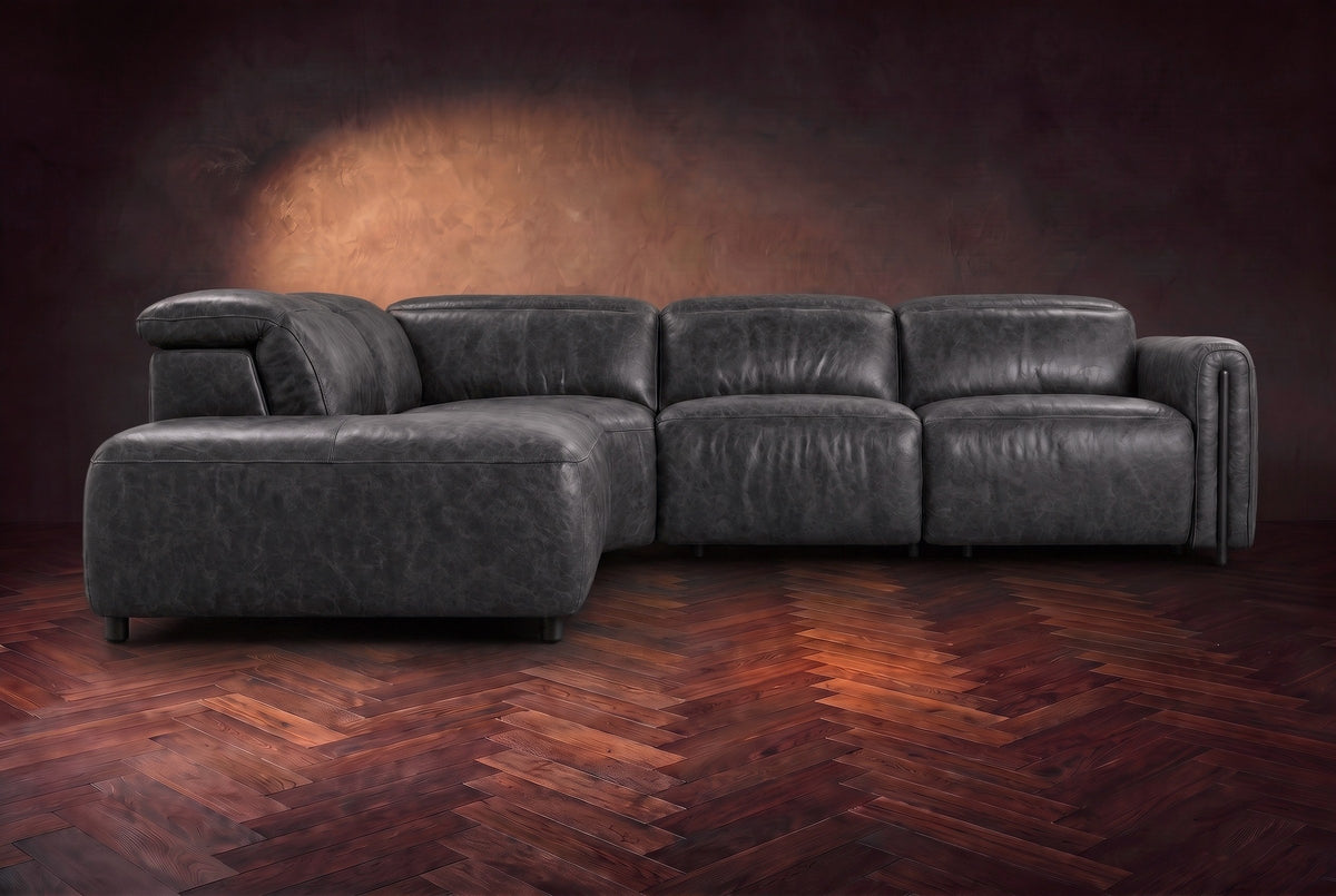 Octavia sectional in Aged Slate on a walnut herringbone floor, seen from the front, footrests closed, Left bumper.