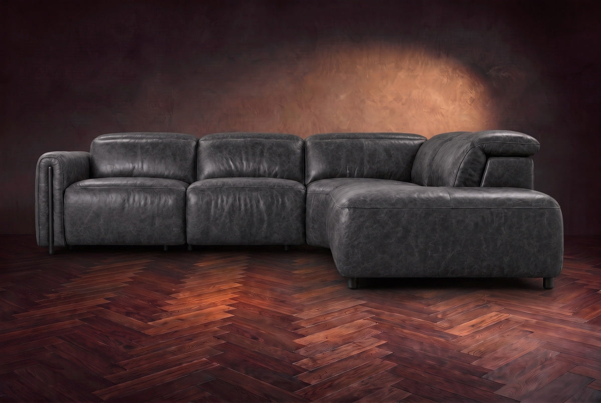 Octavia sectional in Aged Slate on a walnut herringbone floor, seen from the front, footrests closed, Right bumper.