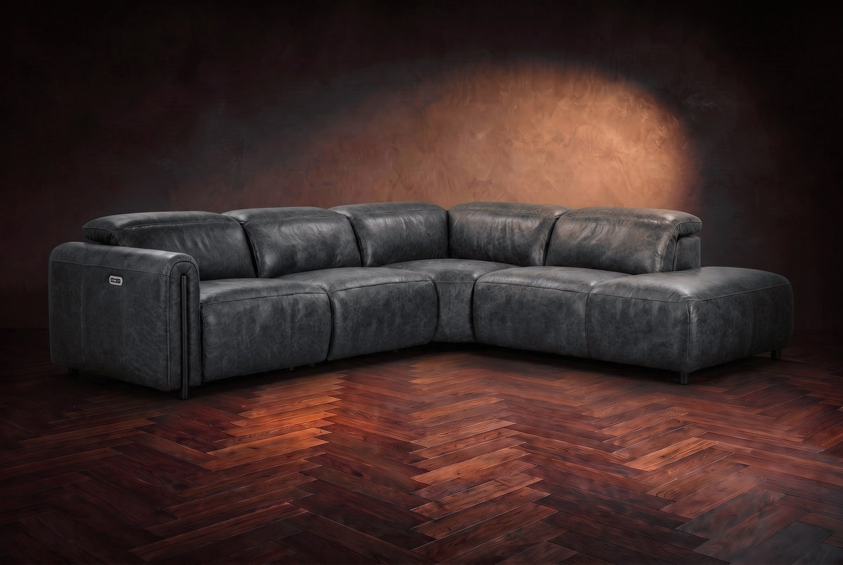 Octavia sectional in Aged Slate on a walnut herringbone floor, three-quarter view, headrests down and footrests closed, Right bumper.