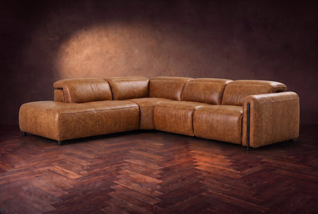 Octavia sectional in Antiqued Caramel on a walnut herringbone floor, three-quarter view, headrests down and footrests closed, Left bumper.