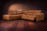 Octavia sectional in Antiqued Caramel on a walnut herringbone floor, three-quarter view, both recliners open and the headrests raised, Left bumper.