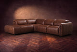 Octavia sectional in Burnished Chestnut on a walnut herringbone floor, three-quarter view, headrests down and footrests closed, Left bumper.