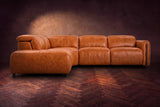 Octavia sectional in Tuscan Cognac on a walnut herringbone floor, seen from the front, footrests closed, Left bumper.