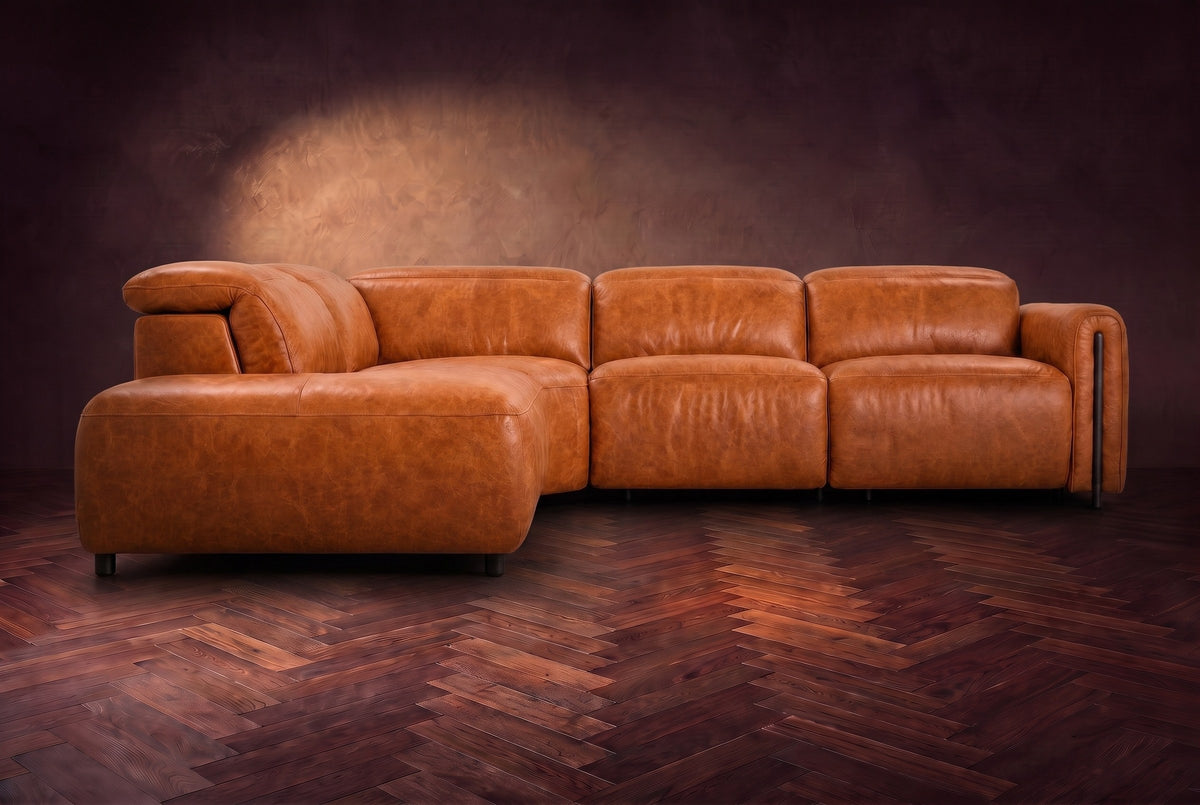 Octavia sectional in Tuscan Cognac on a walnut herringbone floor, seen from the front, footrests closed, Left bumper.