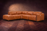 Octavia sectional in Tuscan Cognac on a walnut herringbone floor, three-quarter view, headrests down and footrests closed, Left bumper.