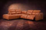 Octavia sectional in Tuscan Cognac on a walnut herringbone floor, three-quarter view, both recliners open and the headrests raised, Left bumper.