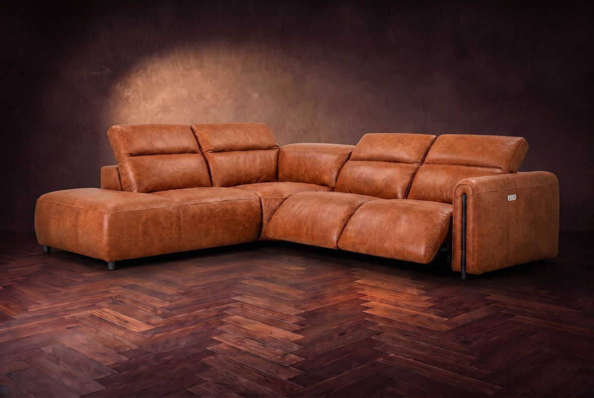 Octavia sectional in Tuscan Cognac on a walnut herringbone floor, three-quarter view, both recliners open and the headrests raised, Left bumper.
