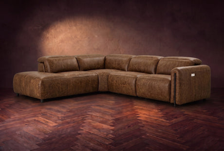 Octavia sectional in Weathered Saddle on a walnut herringbone floor, three-quarter view, headrests down and footrests closed, Left bumper.