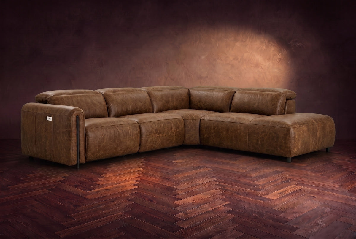 Octavia sectional in Weathered Saddle on a walnut herringbone floor, three-quarter view, headrests down and footrests closed, Right bumper.