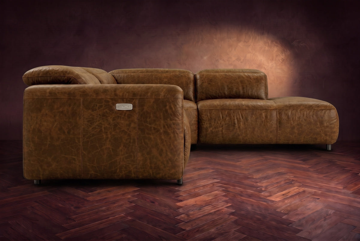 Octavia sectional in Weathered Saddle on a walnut herringbone floor, seen from the arm end, footrests closed, Right bumper.