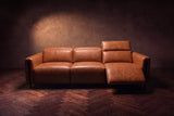 The Octavia 3 seat in Tuscan Cognac distressed full leather on a dark herringbone floor, seen from the front, the right recliner open and its headrest raised. Shown in Tuscan Cognac, 3 seat.
