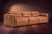 The Octavia 3 seat in Tuscan Cognac distressed full leather on a dark herringbone floor, headrests down and footrests closed. Shown in Tuscan Cognac, 3 seat.