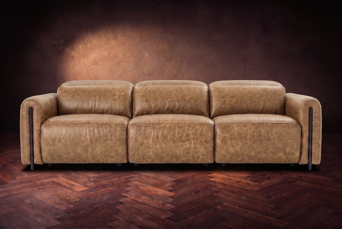 The Octavia 3 seat in Washed Sand distressed full leather on a dark herringbone floor, seen from the front, headrests down. Shown in Washed Sand, 3 seat.