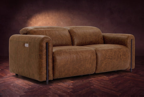 The Octavia loveseat in Weathered Saddle distressed full leather on a dark herringbone floor, headrests down and footrests closed. Shown in Weathered Saddle, Loveseat.