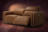 The Octavia loveseat in Weathered Saddle distressed full leather on a dark herringbone floor, seen from the right, the right recliner open and its headrest raised. Shown in Weathered Saddle, Loveseat.
