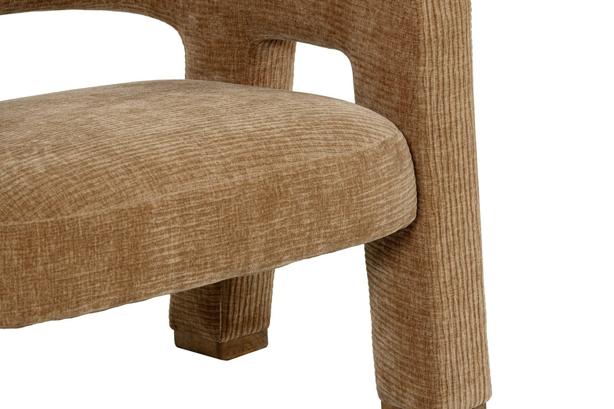 Close-up of the Opi arm turning down into the front leg at a rounded corner, the ribbed Chai fabric and a rubberwood foot