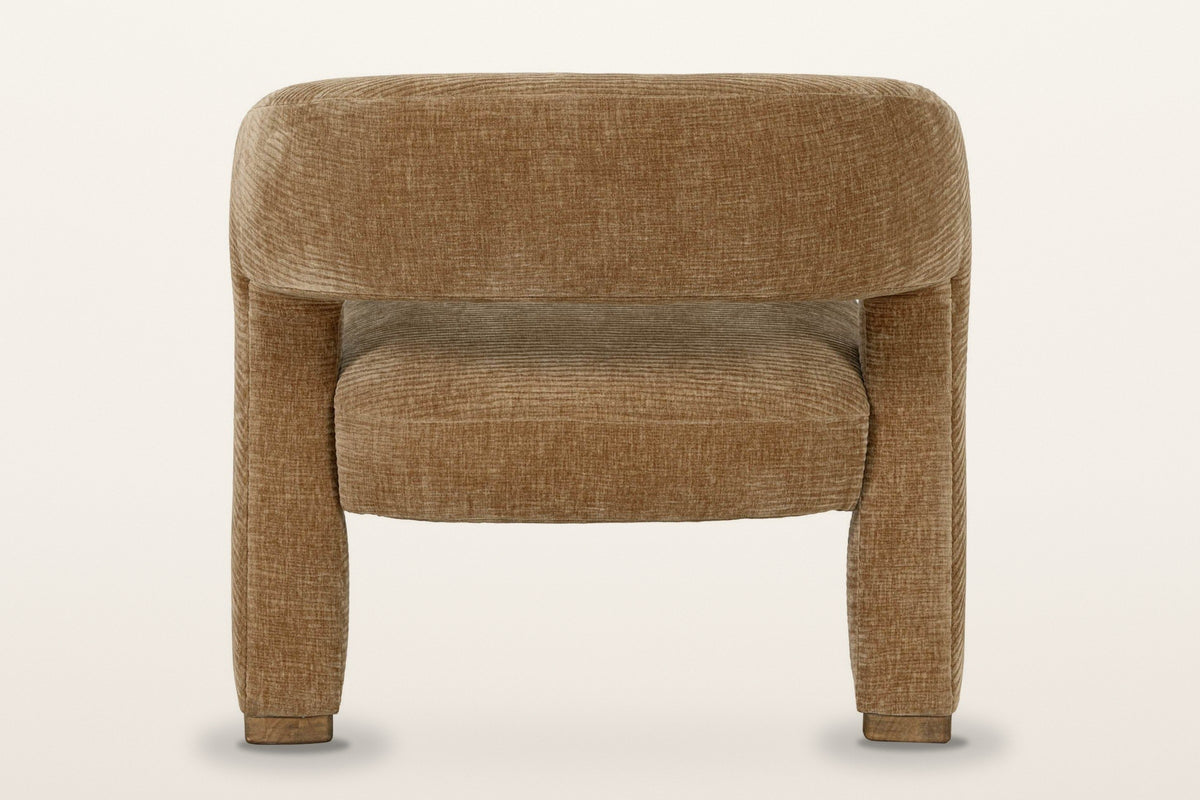 Opi accent chair from behind on a warm white studio backdrop: the curved back band over the seat