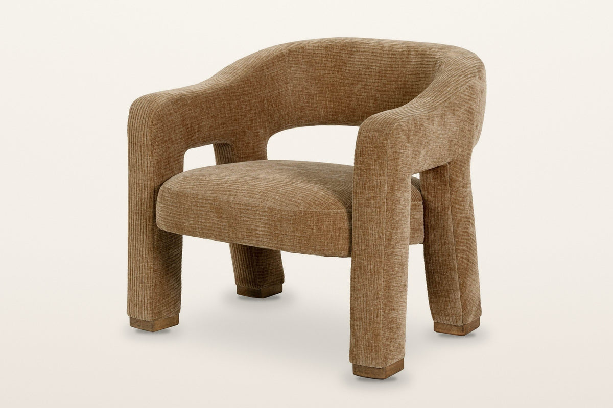 Opi ribbed upholstered accent chair in Chai, three-quarter view on a warm white studio backdrop: thick legs turning into