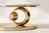 Close-up of the Oriana coffee table's base: the gold ring rising from the oval plinth with the polished gold sphere held in its opening, beneath the stone top