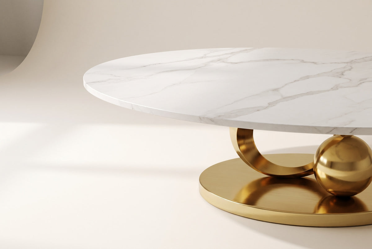 Close-up of the Oriana coffee table's white sintered stone top with soft grey veining, its slim straight edge and the top of the gold ring below