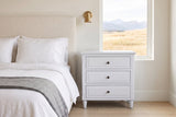 Ortona nightstand in White beside a boucle bed in a Calgary bedroom with foothills in the window